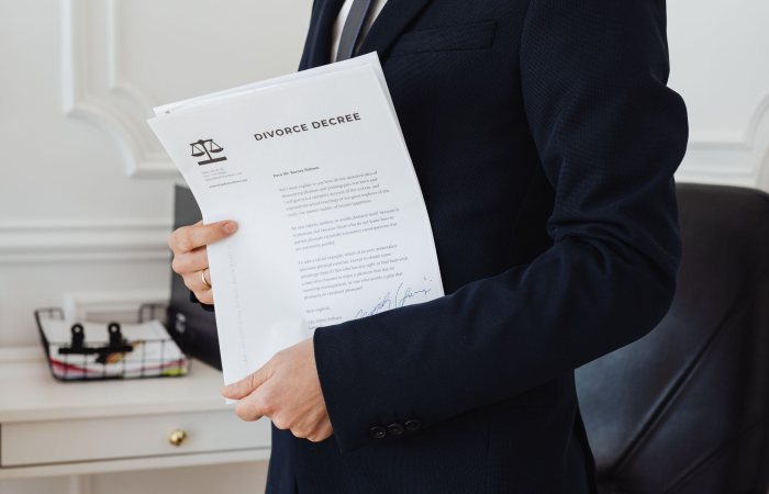 A person holding a divorce decree in an office setting, symbolizing legal proceedings.